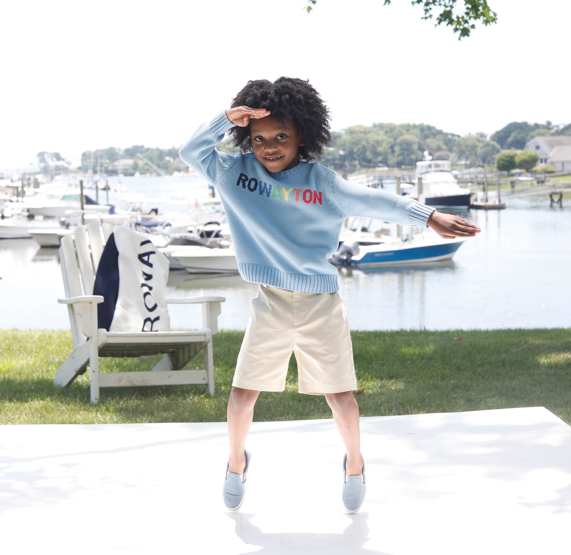 adorable preppy african american boy wearing a light blue sweater with rowayton rainbow letters