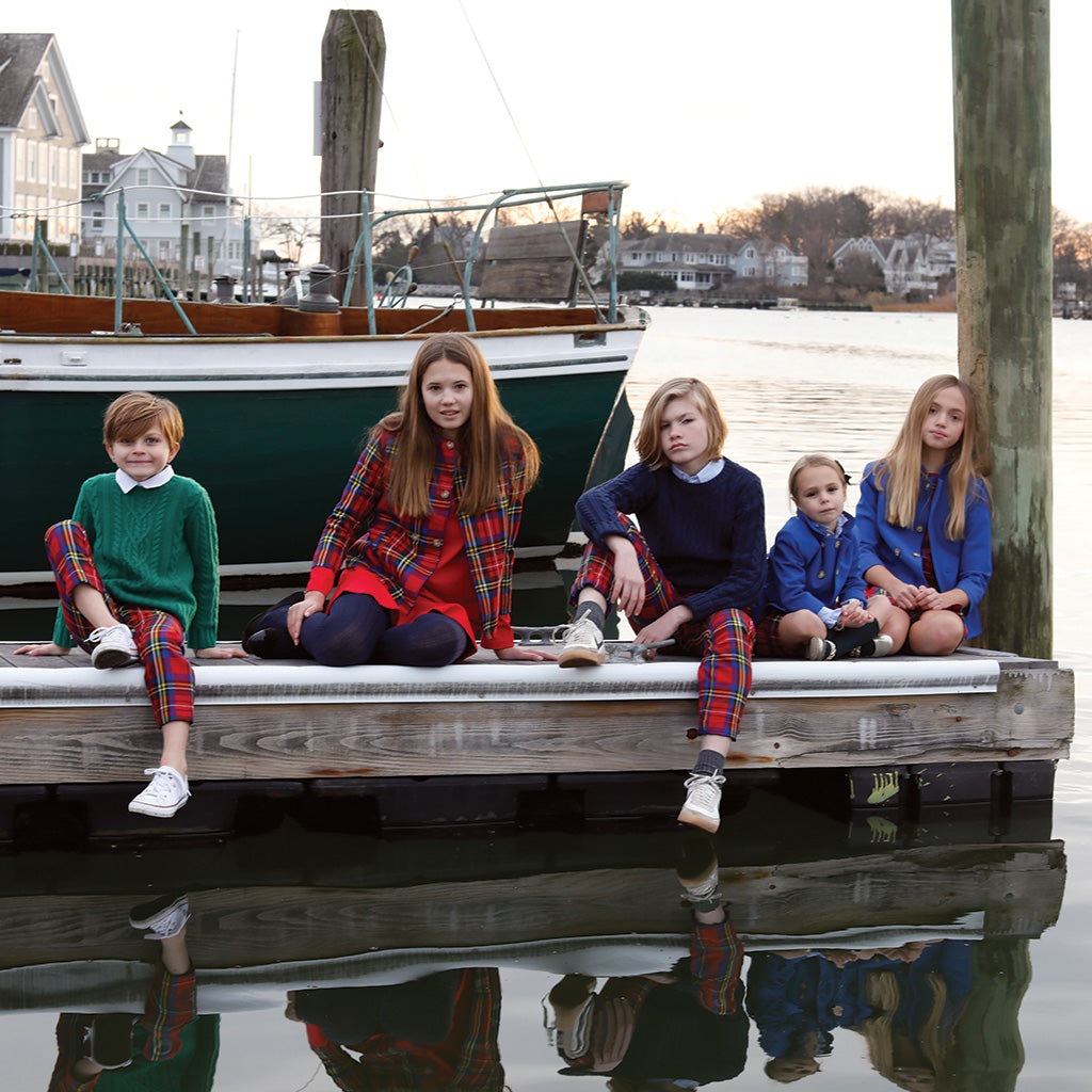 Group of children sitting on dock in holiday clothing